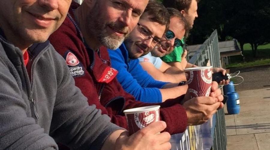 men on a balcony drinking coffee