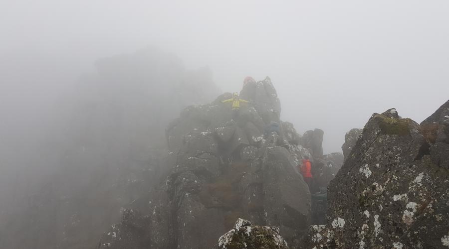 People climbing rocks in the clouds
