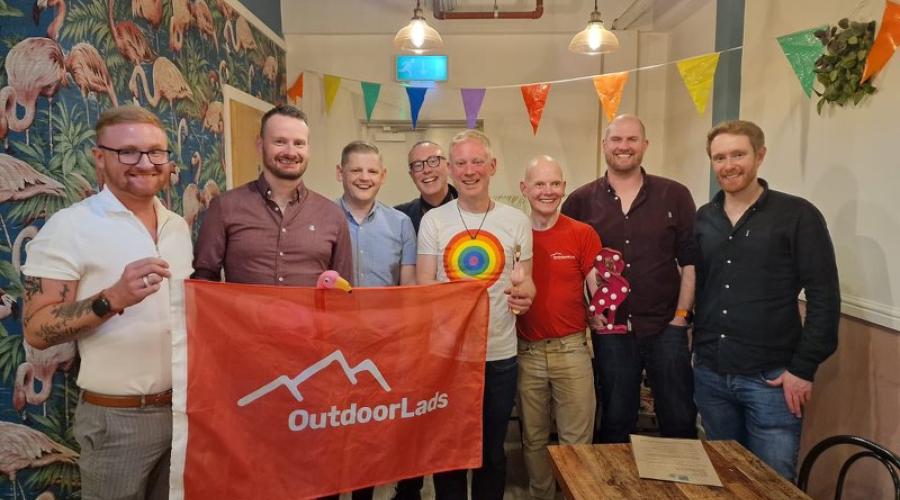 8 guys with flag at Flamingos LGBT cafe Leeds