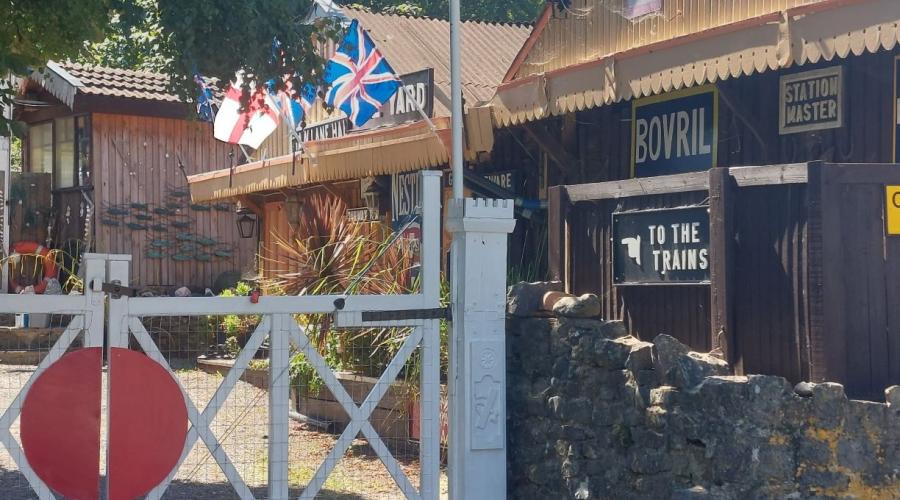 A curious yard with sheds, a railway style gate and an ad for Bovril