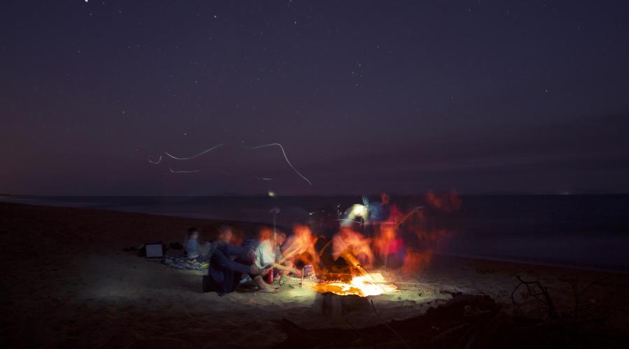 Friends around a bonfire on the beach