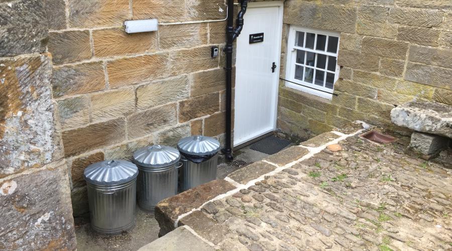 The entrance - white door by the bins