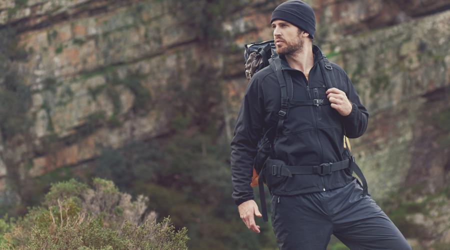 Bearded man wearing hiking clothes on a mountain