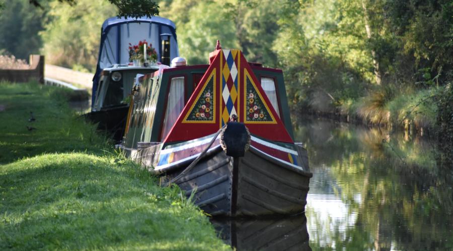 Canal boat sailing along canal