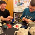 Picture of two outdoor lads enjoing a cuppa and a game of connect 4