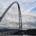 Infinity Bridge archway against a cloudy sky