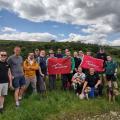 Guys on walk in countryside with a red flag