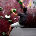 Boulderer climbing up a wall