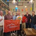 8 guys with flag at Flamingos LGBT cafe Leeds 