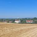 A ploughed field, some houses and Severn Bridge in distance