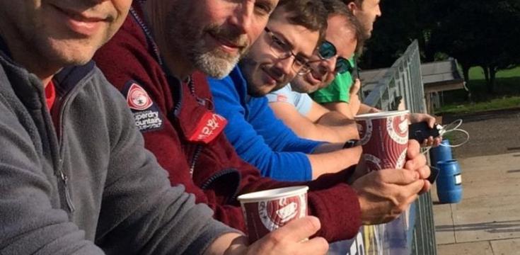 men on a balcony drinking coffee