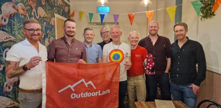 8 guys with flag at Flamingos LGBT cafe Leeds 