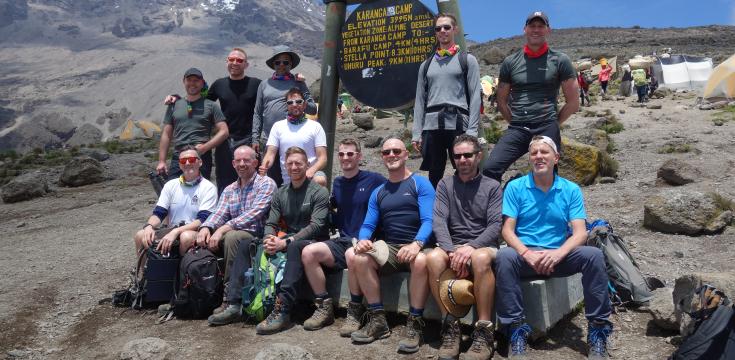 OutdoorLads & Pride Expeditions at a Kilimanjaro camp sign