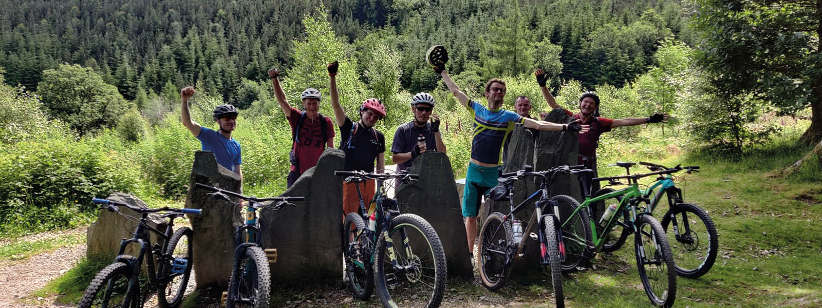 Group of cyclists with arms in the air