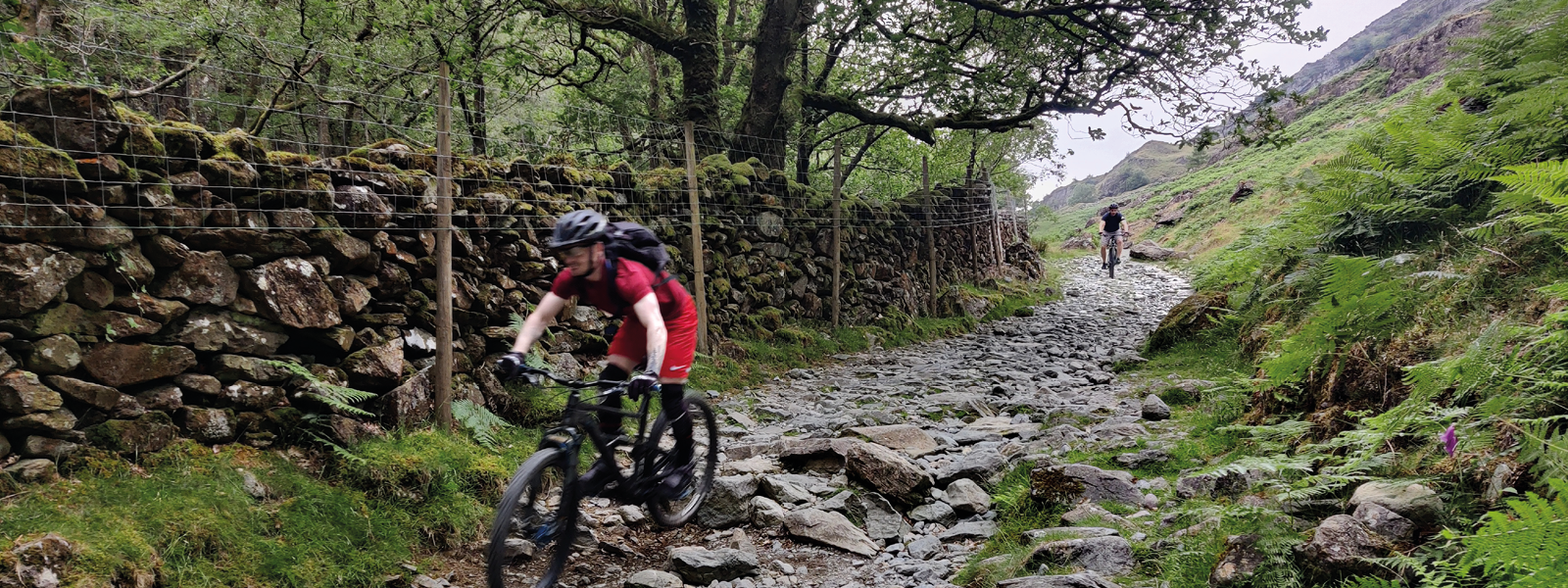 Two mountain bikers riding along a rocky path